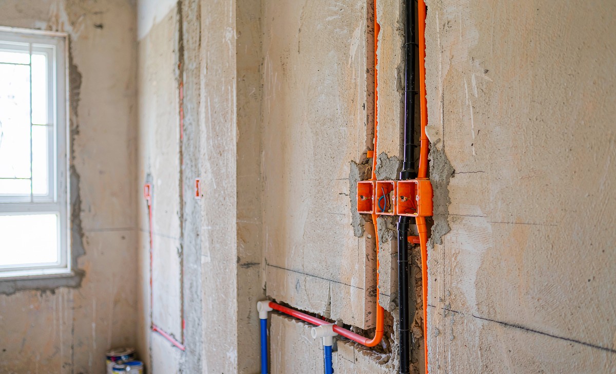 Electrical conduits and water pipes neatly routed in a wall chase