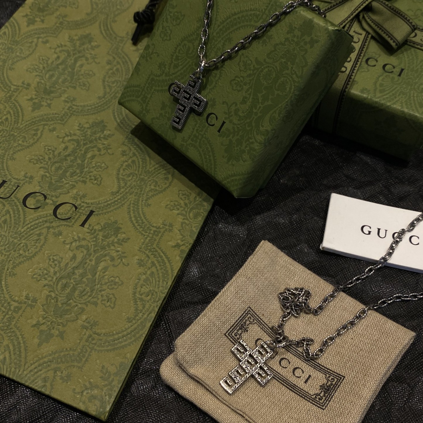 Gucc* の G 文字入りの十字架型の透かし彫りネックレス