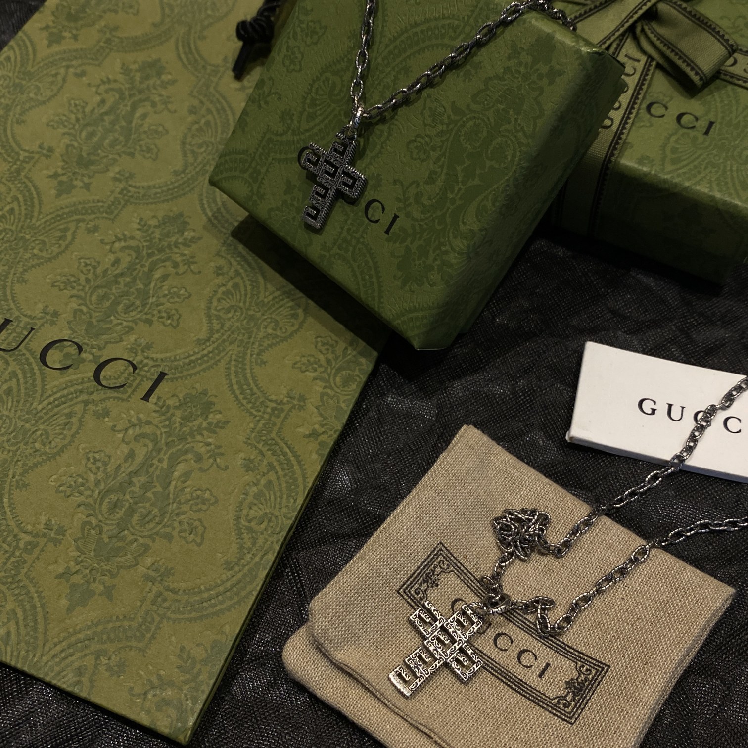 Gucc* の G 文字入りの十字架型の透かし彫りネックレス