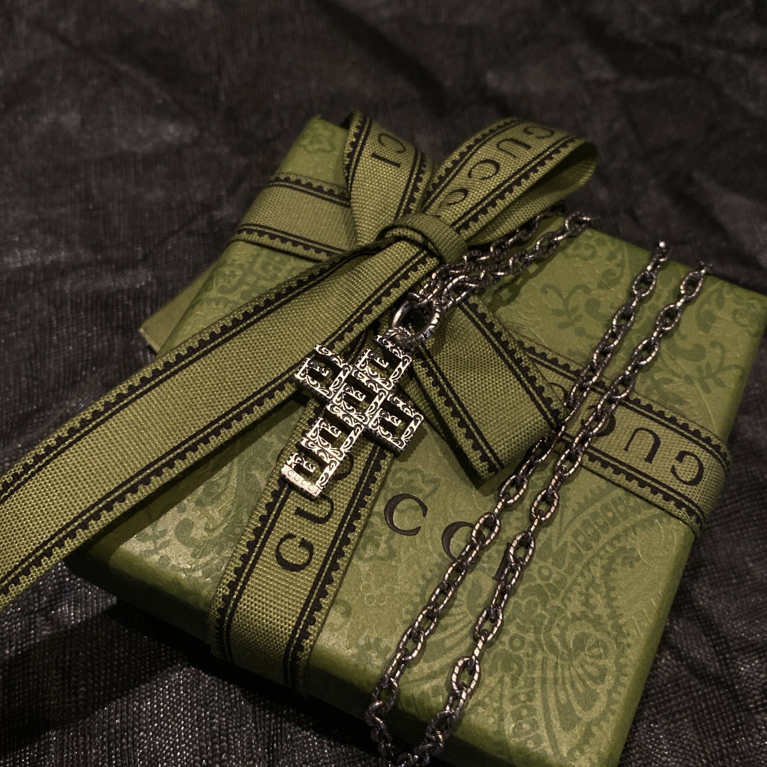 Gucc* の G 文字入りの十字架型の透かし彫りネックレス