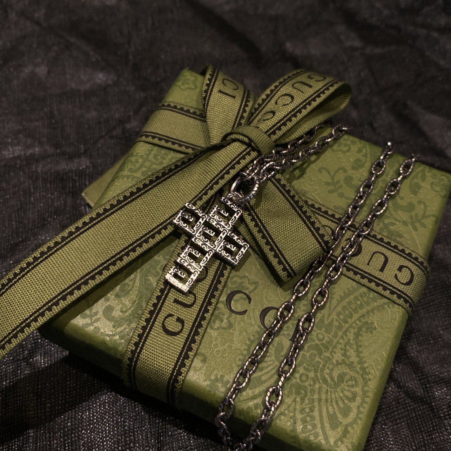 Gucc* の G 文字入りの十字架型の透かし彫りネックレス