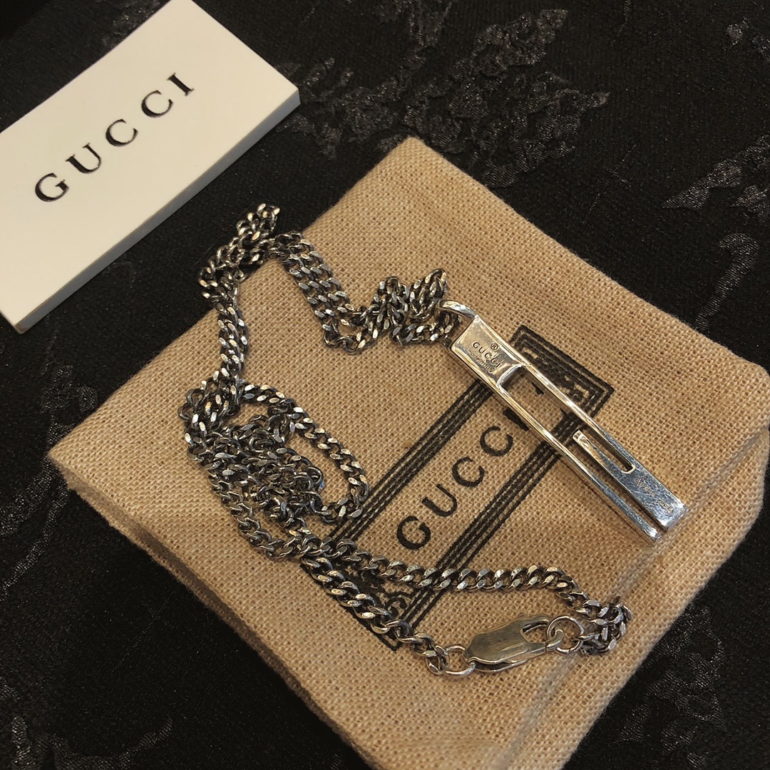 Gucc* のカップル用 G 文字入りの縦長ペンダント