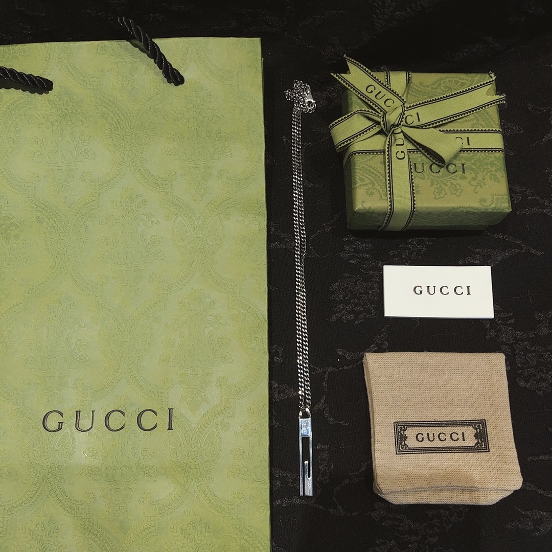 Gucc* のカップル用 G 文字入りの縦長ペンダント