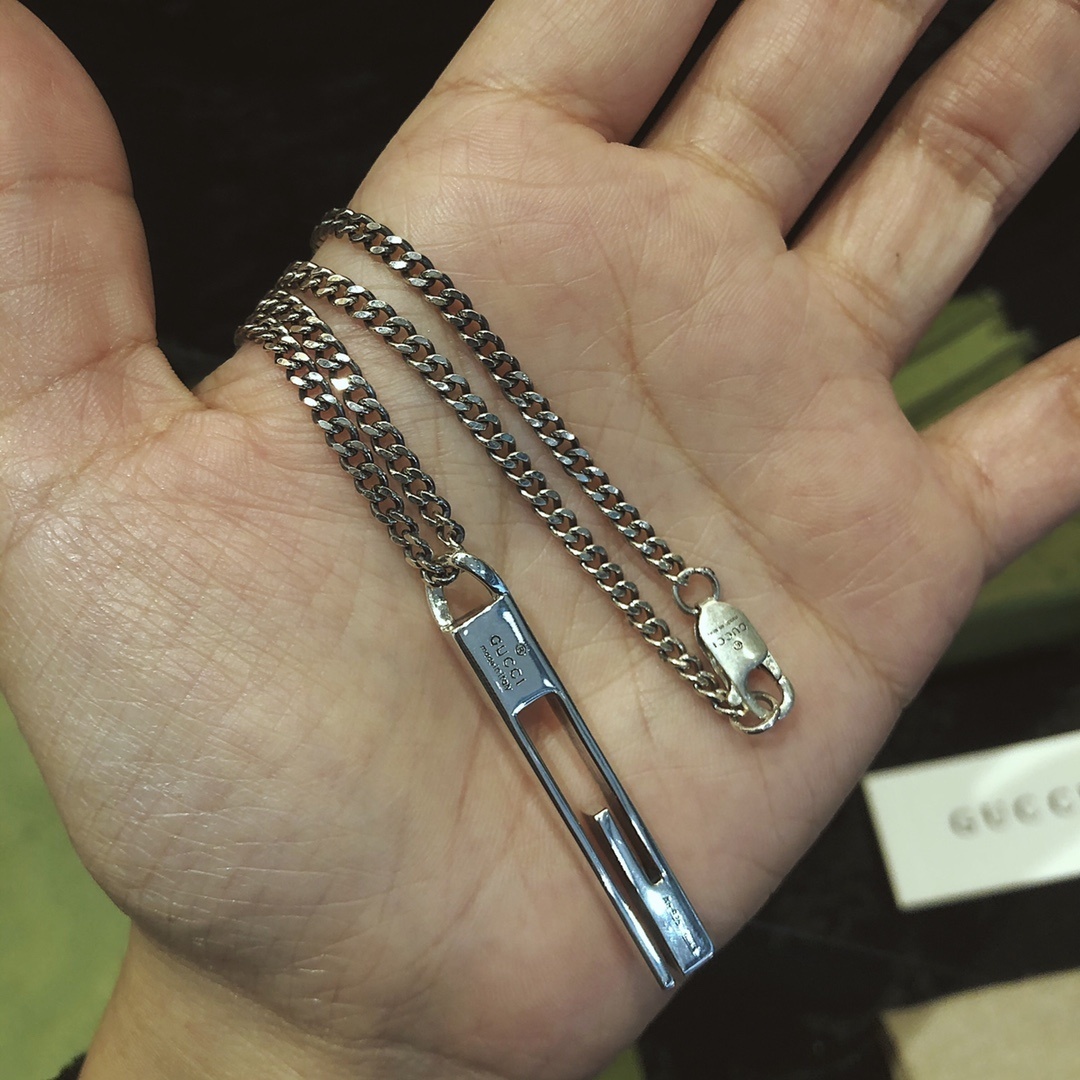 Gucc* のカップル用 G 文字入りの縦長ペンダント