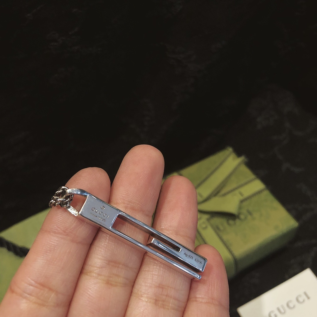 Gucc* のカップル用 G 文字入りの縦長ペンダント