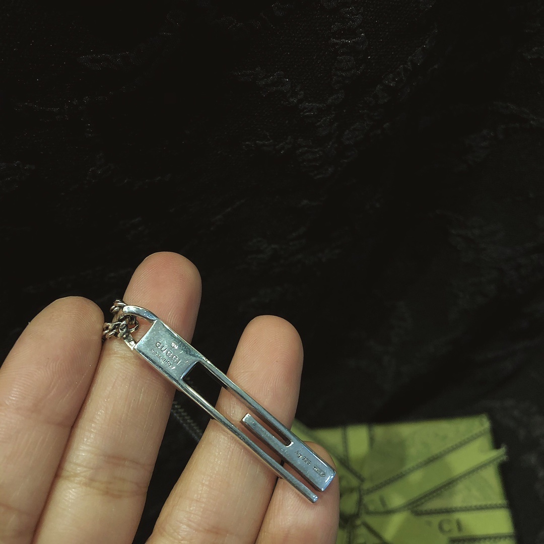 Gucc* のカップル用 G 文字入りの縦長ペンダント