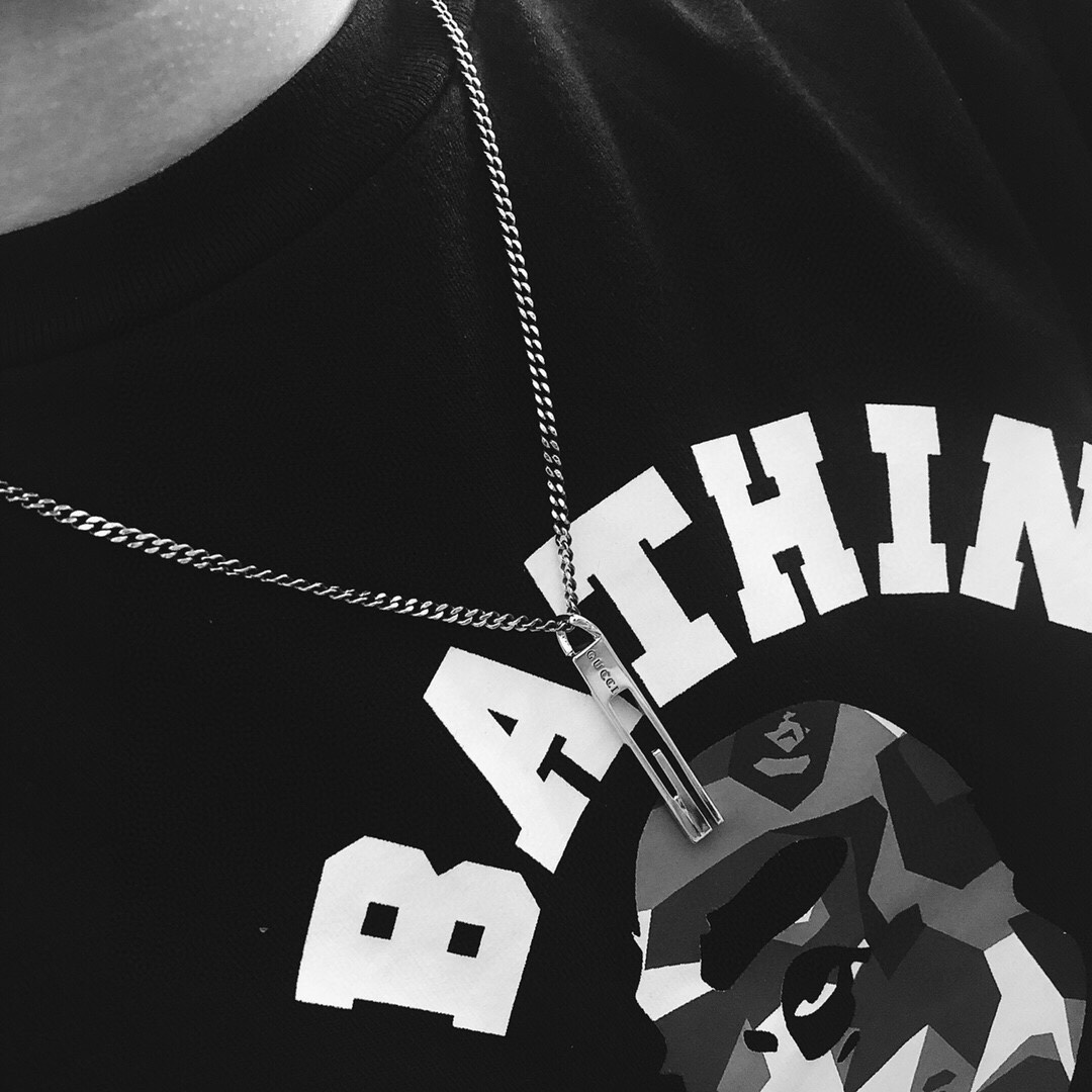 Gucc* のカップル用 G 文字入りの縦長ペンダント