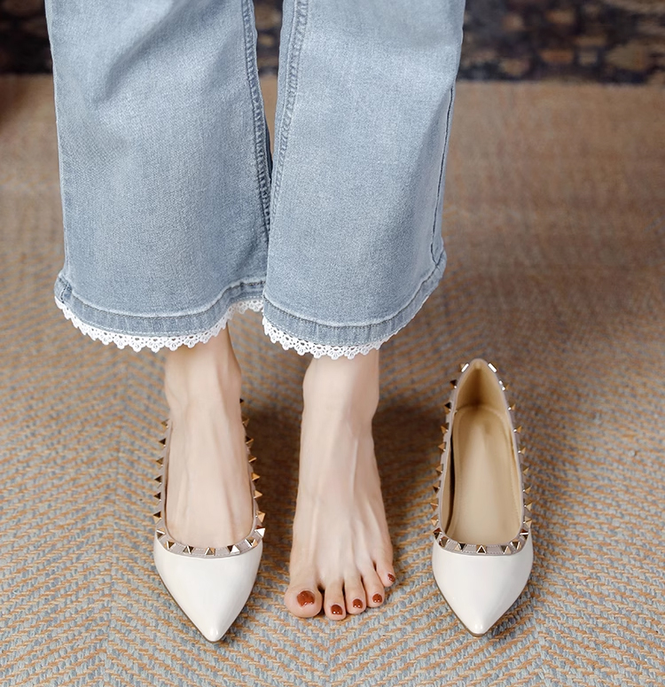 春夏のデニムコーデを格上げするアイボリーのスタッズパンプス。清潔感のある白エナメルは、GW(ゴールデンウィーク)の旅行や街歩きにもおすすめ
