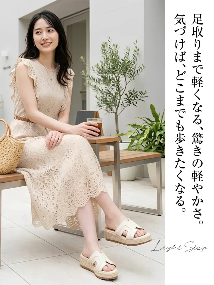 上品なレースワンピースを着た30代女性の足元。アイボリーのHデザイン・ジュートウェッジソールサンダルを合わせた大人カジュアルな休日コーデ。軽量で疲れない夏のきれいめスタイル