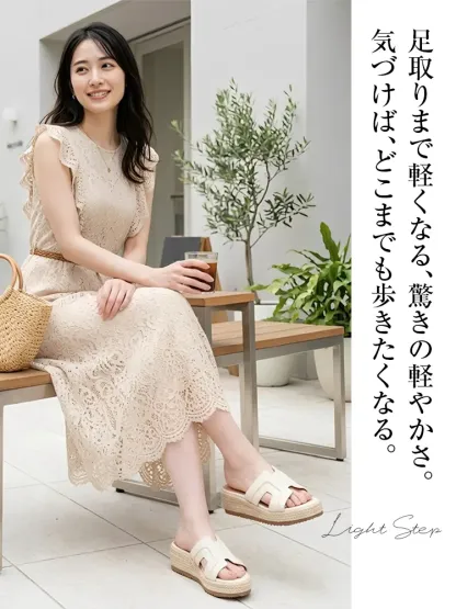 上品なレースワンピースを着た30代女性の足元。アイボリーのHデザイン・ジュートウェッジソールサンダルを合わせた大人カジュアルな休日コーデ。軽量で疲れない夏のきれいめスタイル