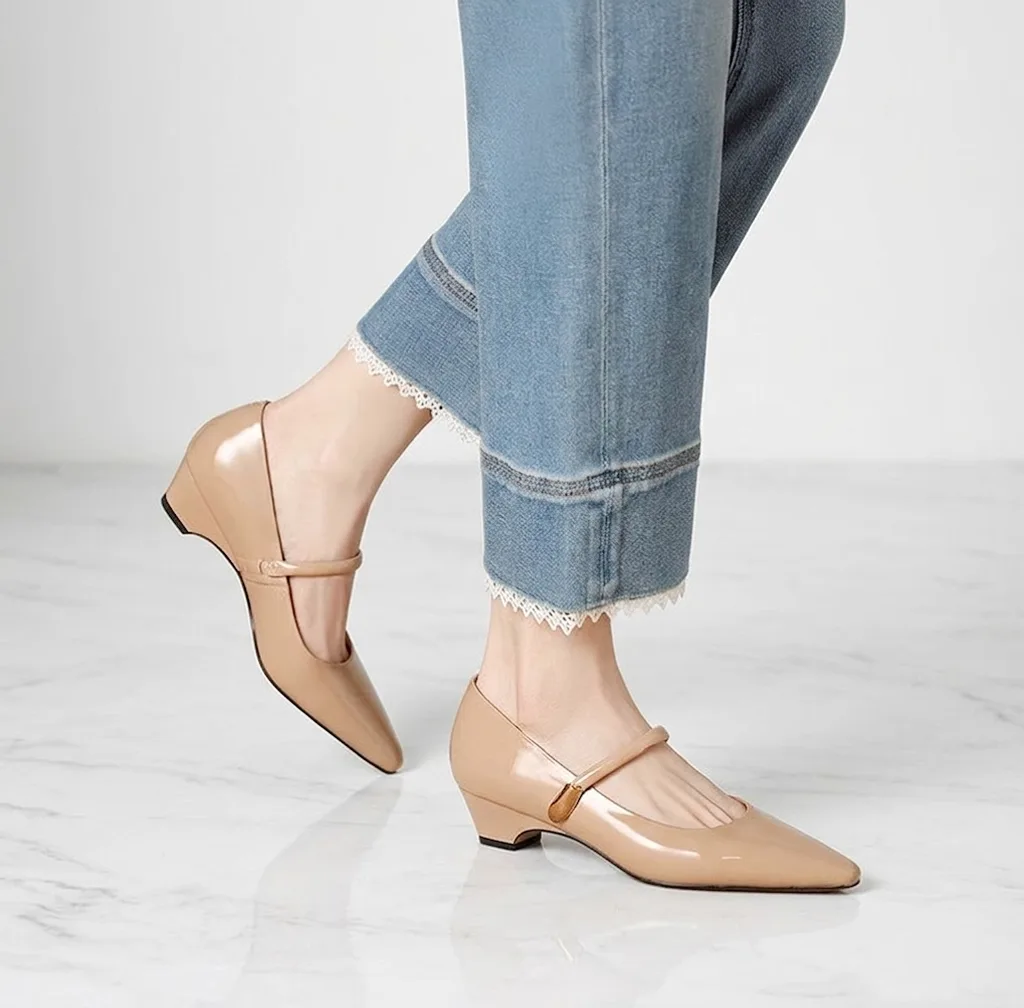 カジュアルなデニムスタイルにも品よく馴染むアプリコット（ベージュ）のエナメルパンプス。ストラップ付きでパカパカせず、たくさん歩く休日のお出かけにもぴったり