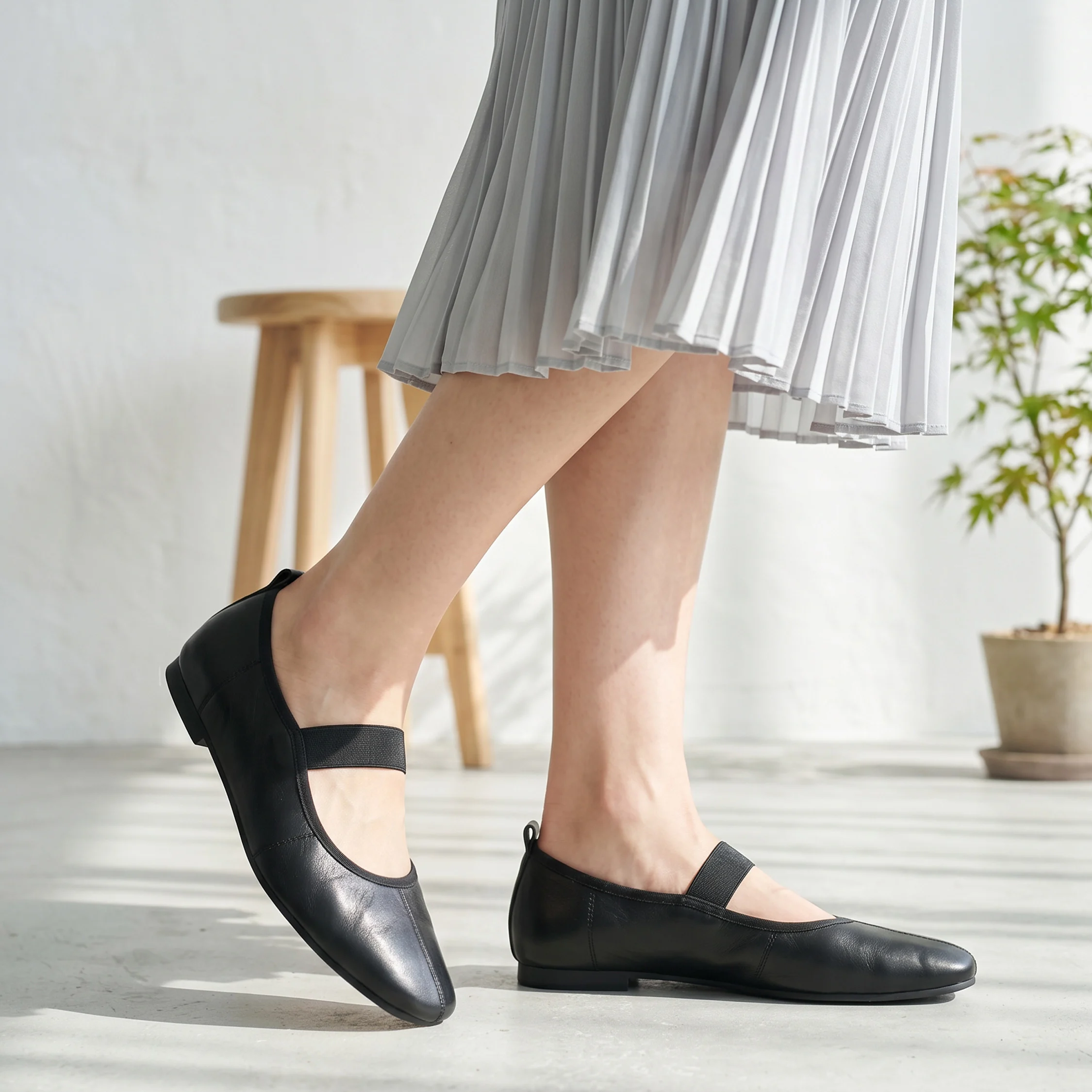 ブラックのレディース ストラップパンプス 着用イメージ スカートに合う 上品で歩きやすいフラットシューズ