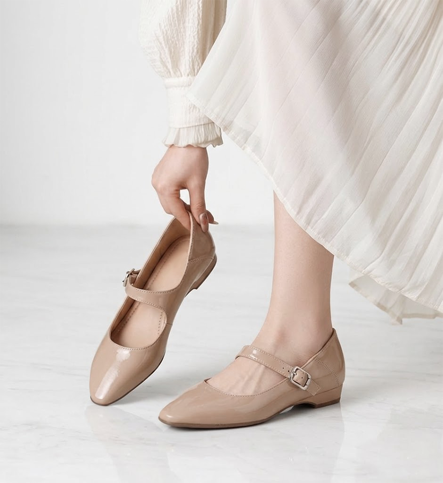 女性がベージュのマリージェーンを履こうとしているシーン。片手で持てる軽さと、足に優しくフィットする柔らかさを表現。幅広・甲高でも安心の履き心地。