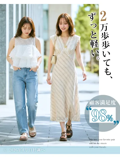 ブラウンとベージュのサンダルを履いて街を歩く二人の女性。ワンピースやデニムにも合うデザインで、2万歩歩いても疲れない軽さが特徴。休日のお出かけにぴったりなレディースサンダル。