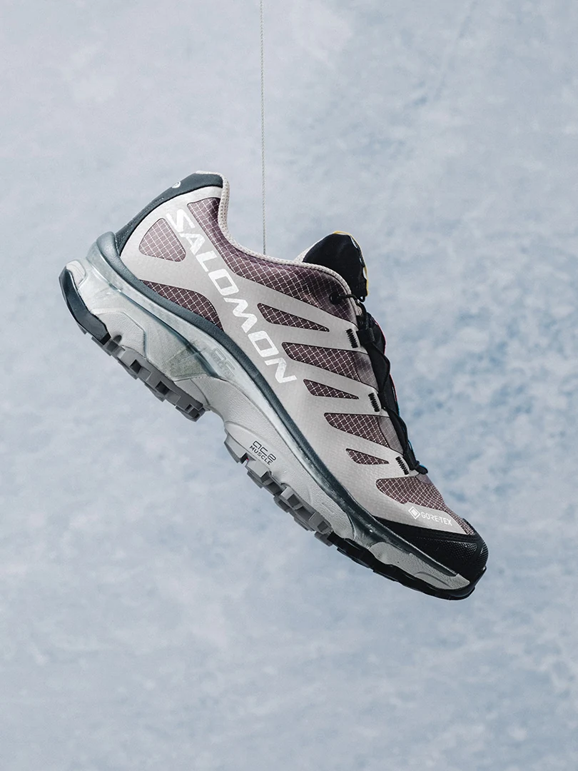 Salomon XT-4 OG GORE-TEX shoe suspended against a cloudy sky