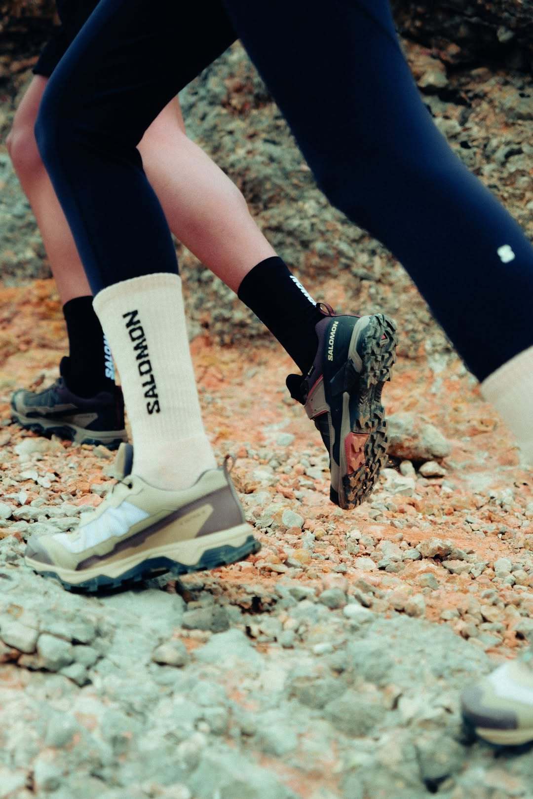 Hikers moving across a rocky trail in Salomon footwear