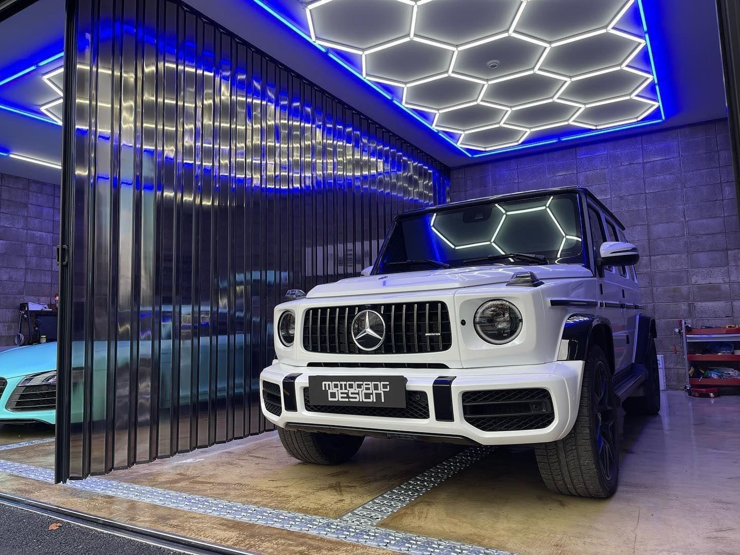 Blue framed hexagon LED lighting for professional car modification workshop