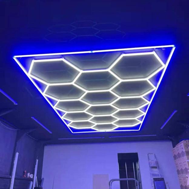 Bright hexagon LED light with blue edging enhancing garage workspace