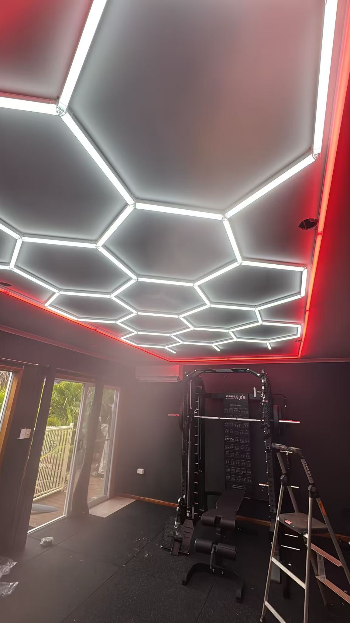 Bright hexagon LED light with red edging for modern home gym interior
