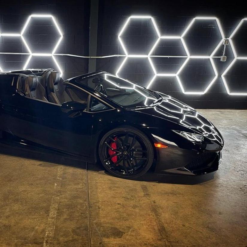 Hexagon LED wall-mounted light providing bright illumination in auto repair shop