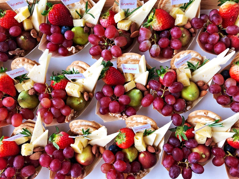Individually-portioned cheese platters on bamboo grazing boats