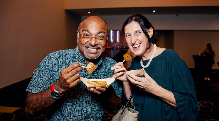 Happy party guests in the midst of enjoying food from Splatter's grazing table spread