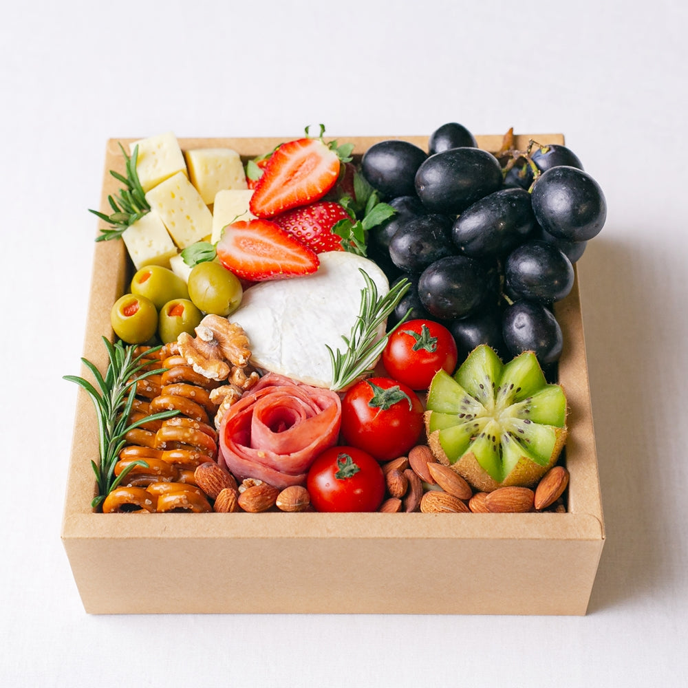 {"default":"Splatter's mini cheese grazing platter box, filled to the brim with a small soft cheese wheel, gouda cheese cubes, grapes, strawberries, kiwi, cherry tomatoes, olives, turkey roll rose, mini pretzel crackers and roasted nuts. "}
