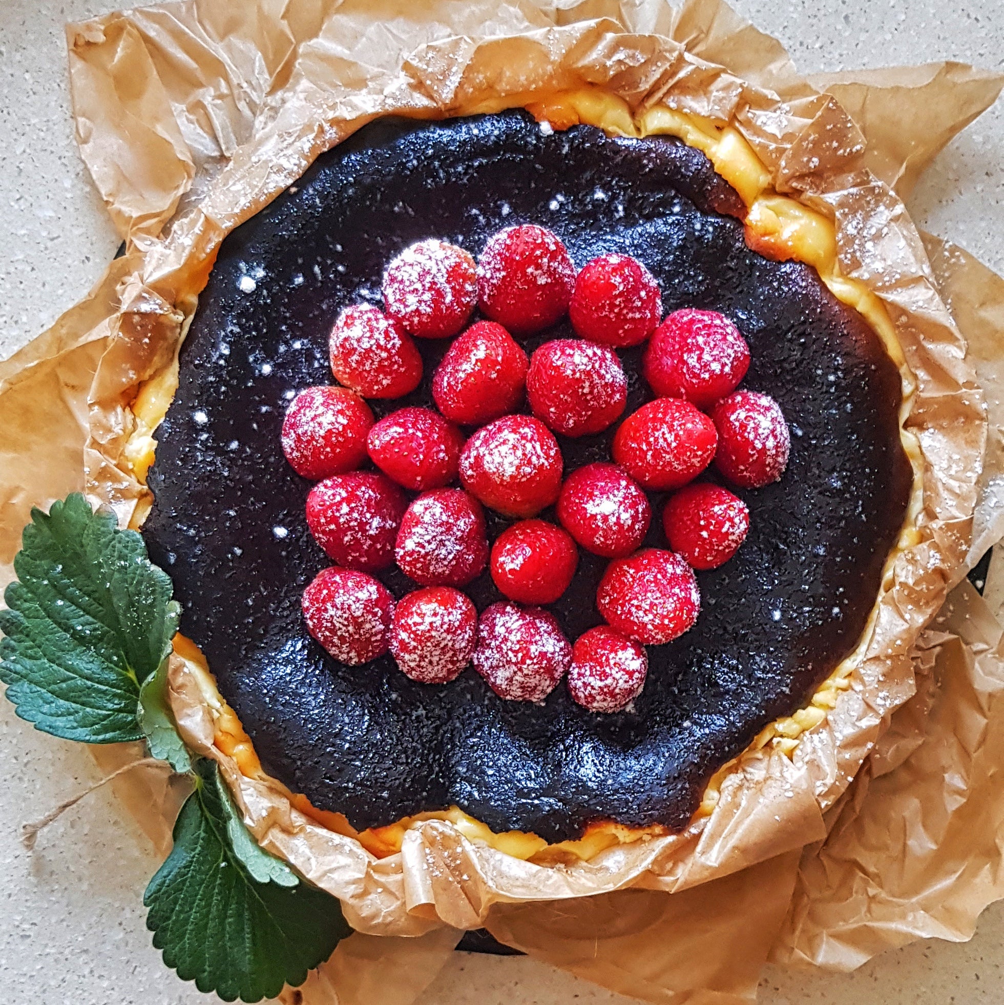 Splatter's homemade basque burnt cheesecake topped with premium fresh strawberries with icing sugar dustingrries