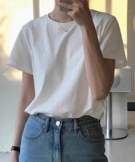 男女兼用の純綿の白いTシャツ。シンプルなスタイルで、重ね着にも万能。ゆったりとしたベーシックなトップス