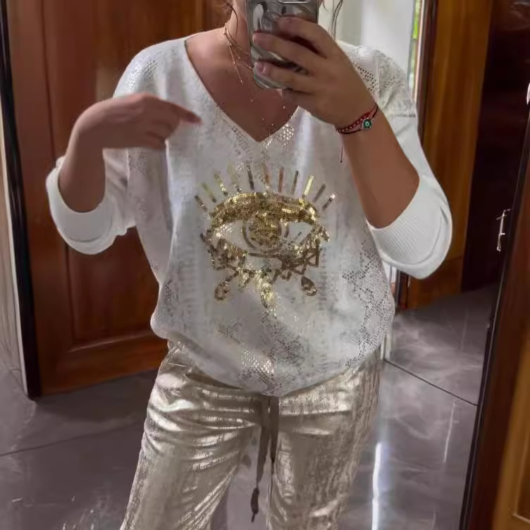 Conjunto de dos piezas formado por top de lentejuelas de moda y pantalón marrón.