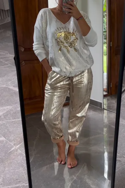 Conjunto de dos piezas formado por top de lentejuelas de moda y pantalón marrón.