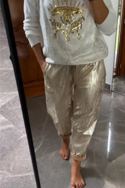 Conjunto de dos piezas formado por top de lentejuelas de moda y pantalón marrón.