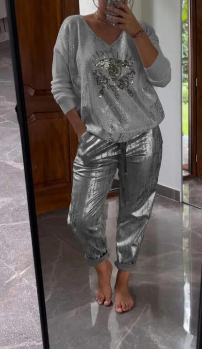Conjunto de dos piezas formado por top de lentejuelas de moda y pantalón marrón.