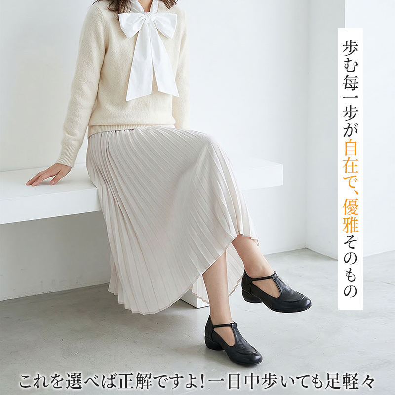 ホワイトのプリーツスカートと本革Tストラップパンプスを合わせた優雅なコーディネート