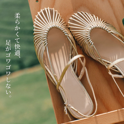 本革ストラップフラットサンダル 木製の台に並べられた美しいデザインの近接撮影