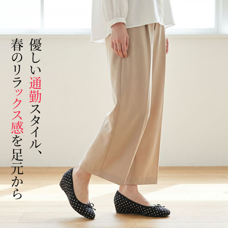 ベージュのパンツに合わせた優しい通勤スタイルのポルカドットパンプス