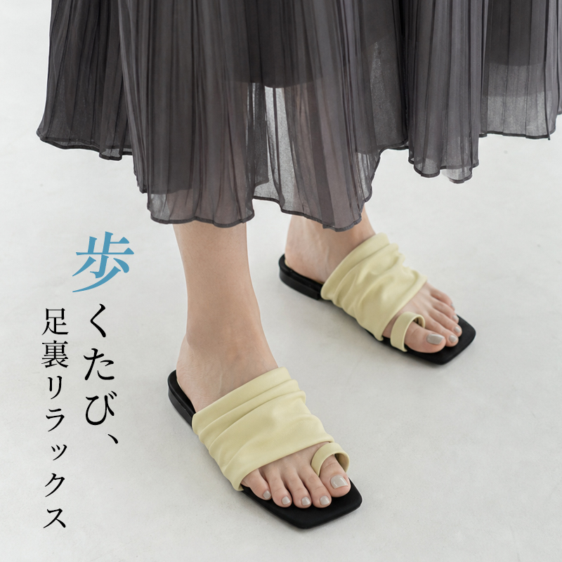 イエローのギャザーサンダルを着用したナチュラルスタイルの足元