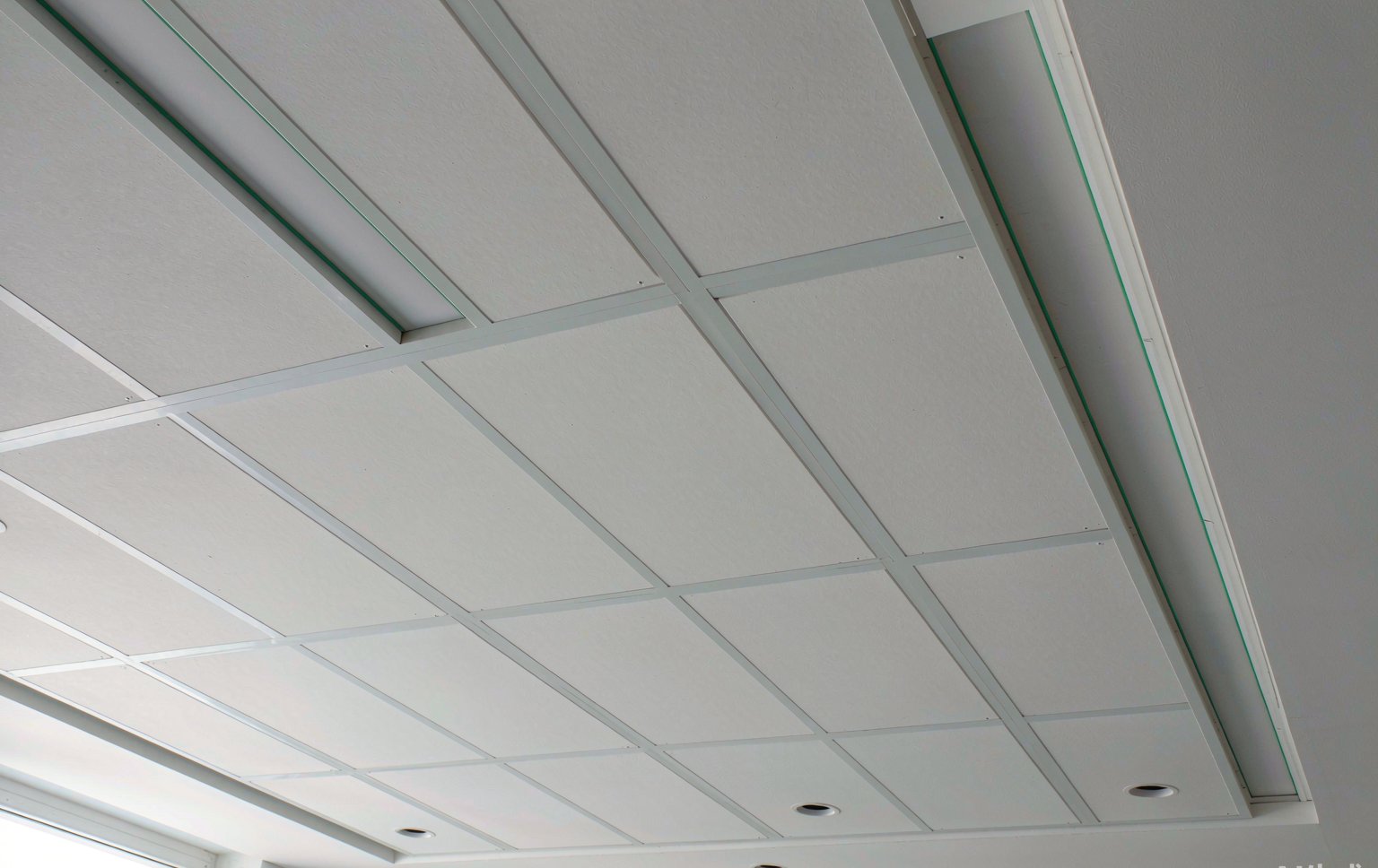 A framed false ceiling with a slim recessed cove lighting trough