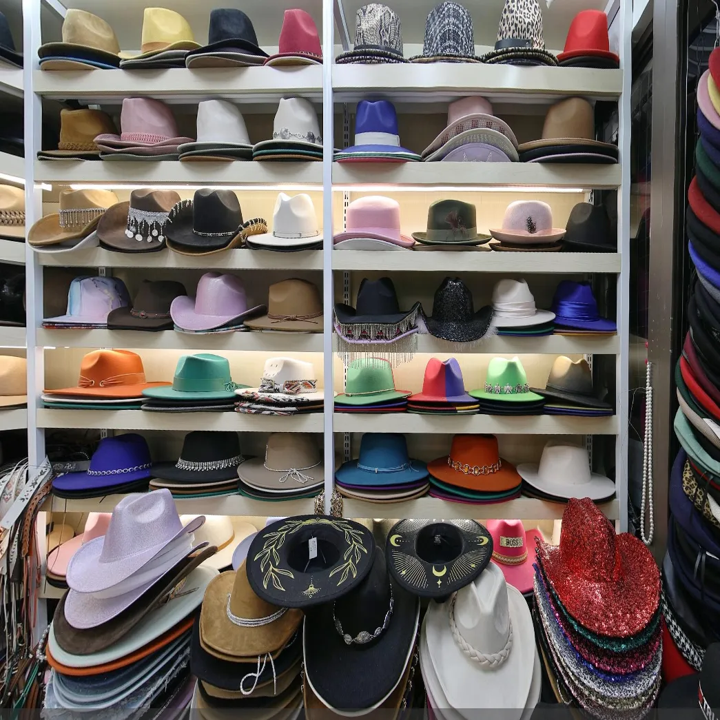 Assorted party fedora hats, cowboy hats, wide brim hats, sequin performance hats display for carnival halloween fancy dress bulk