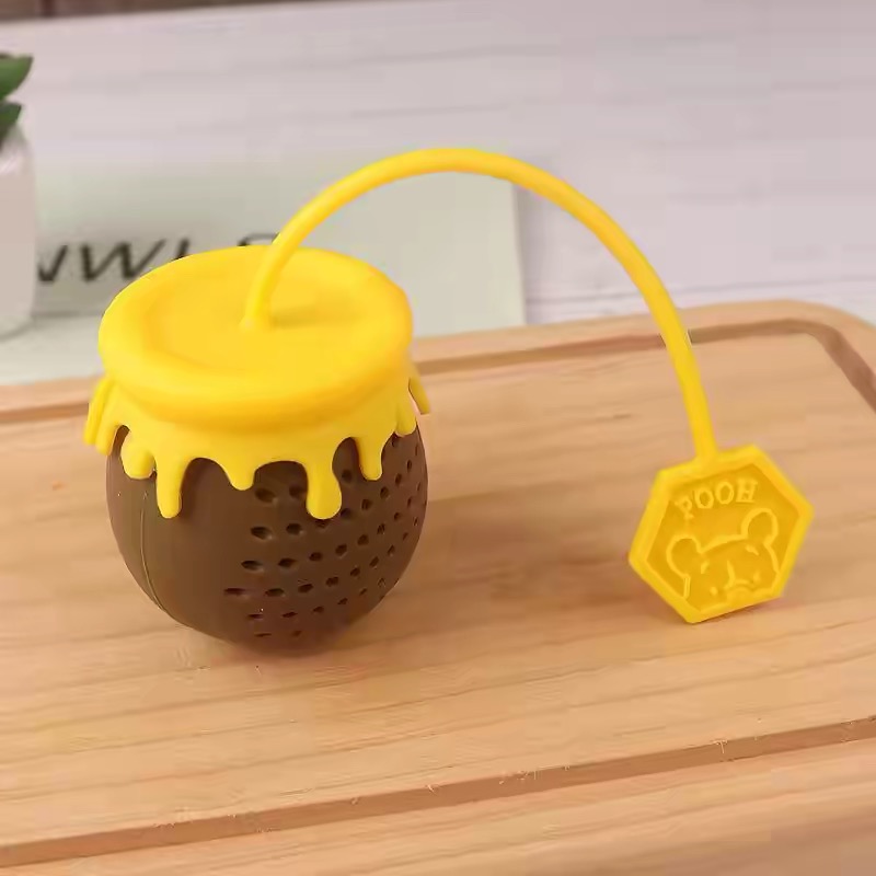 pooh honey pot tea infuser hanging on ceramic mug kitchen tea brewing scene