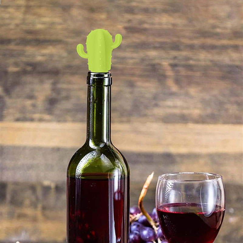 light green saguaro cactus food grade silicone wine bottle stopper inserted on green wine bottle wooden background scene