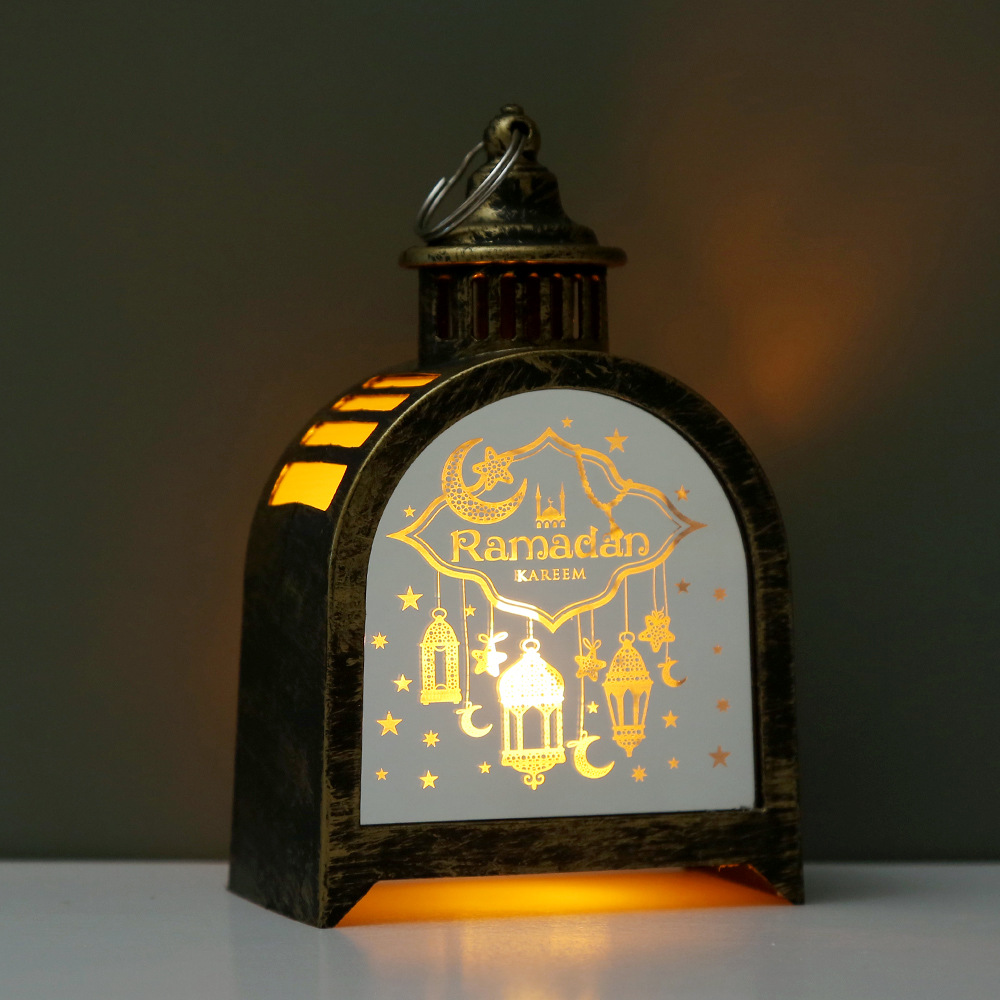 Four arch ramadan lanterns arranged on white desktop with book background