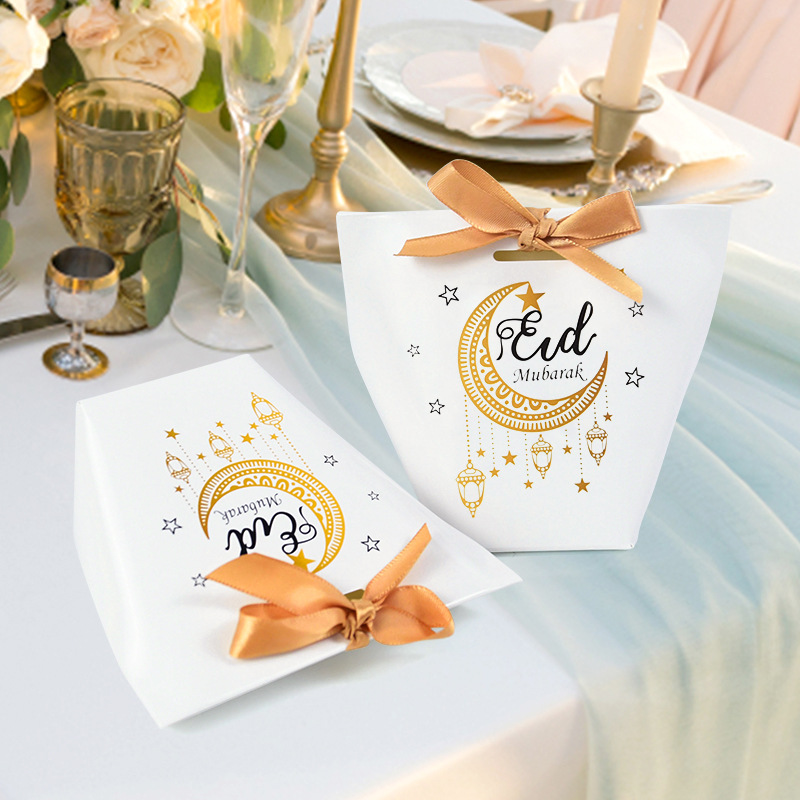 Close‑up of golden moon lantern print and gold ribbon bow on eid favor box
