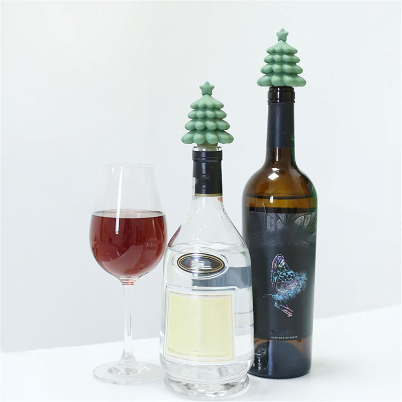 matte sage green star top christmas tree food grade threaded silicone wine bottle stopper inserted on liquor bottles white table scene