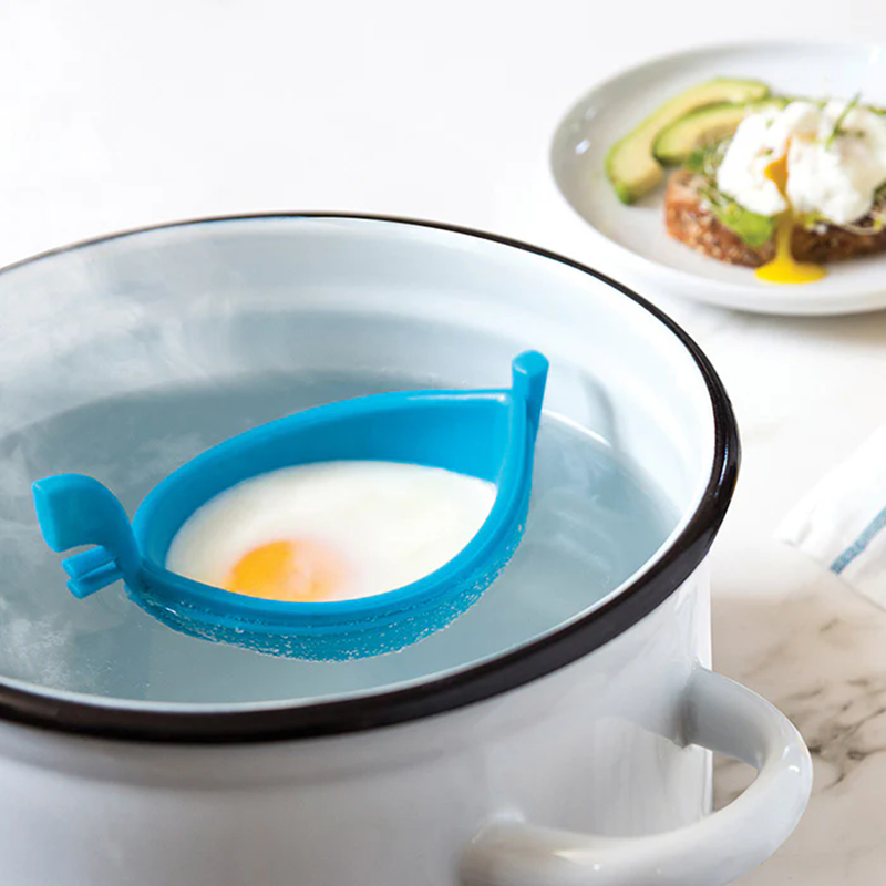 bright blue boat silicone floating poached egg maker in enamel pot white background cooking scene