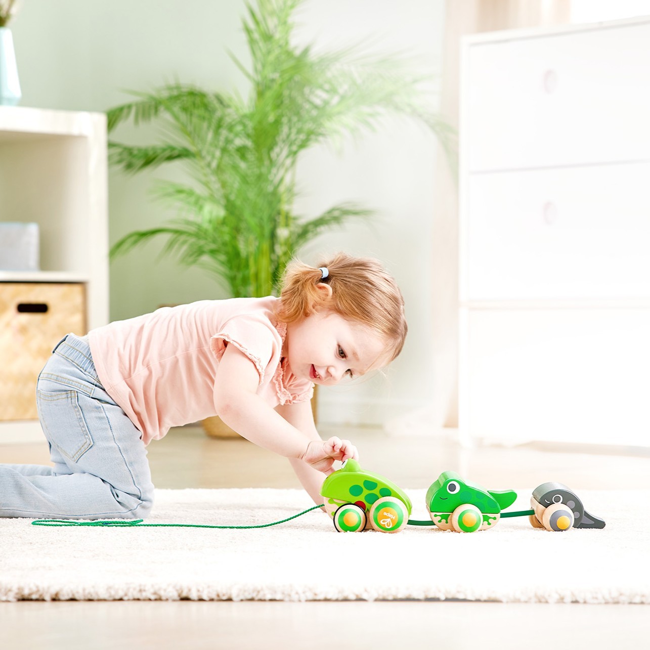 幼兒拉動繩子帶領青蛙媽媽散步，訓練粗大動作與平衡力