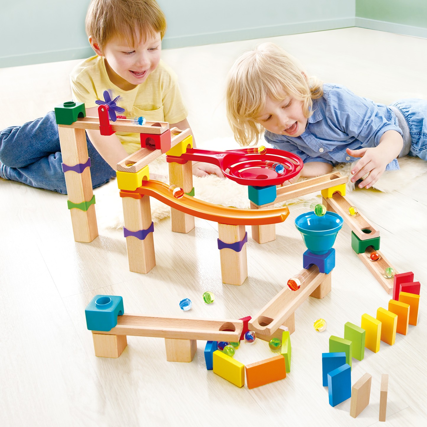 兒童正在搭建彩色木質軌道滾珠遊戲積木組合