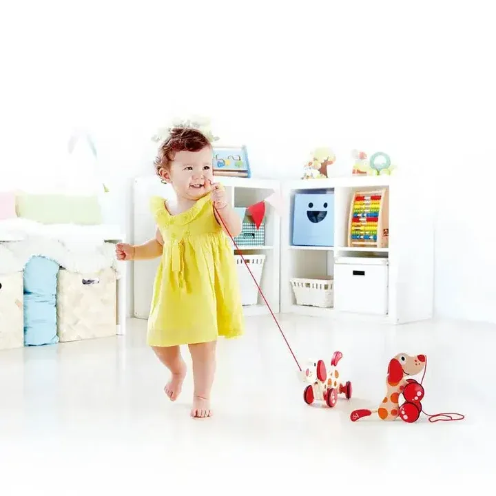 幼兒拖拉木製小狗玩具進行大肌肉訓練