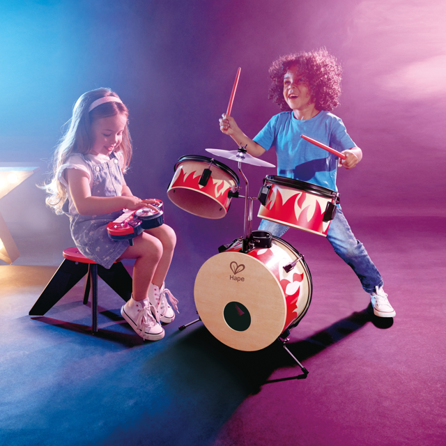 兒童在客廳使用彩色打擊樂器組進行音樂活動