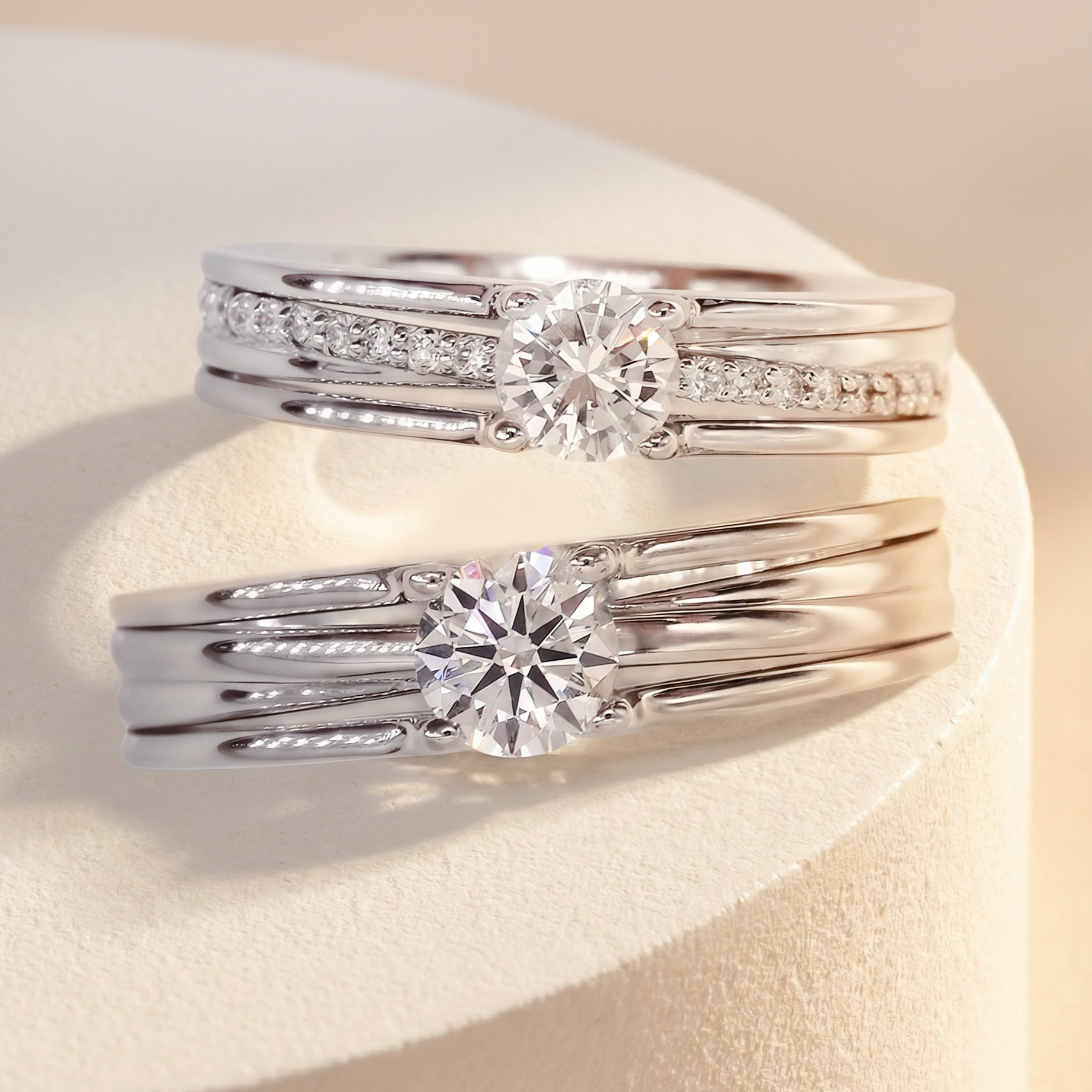 DIABOND 銀白色天然鑽石結婚對戒平放展示。戒指採用多層次平行線條 (Multi-band) 與鏤空設計。上方女戒鑲嵌 0.4ct 主鑽及閃爍排鑽；下方男戒鑲嵌 0.5ct 主鑽，展現寬版俐落風格。